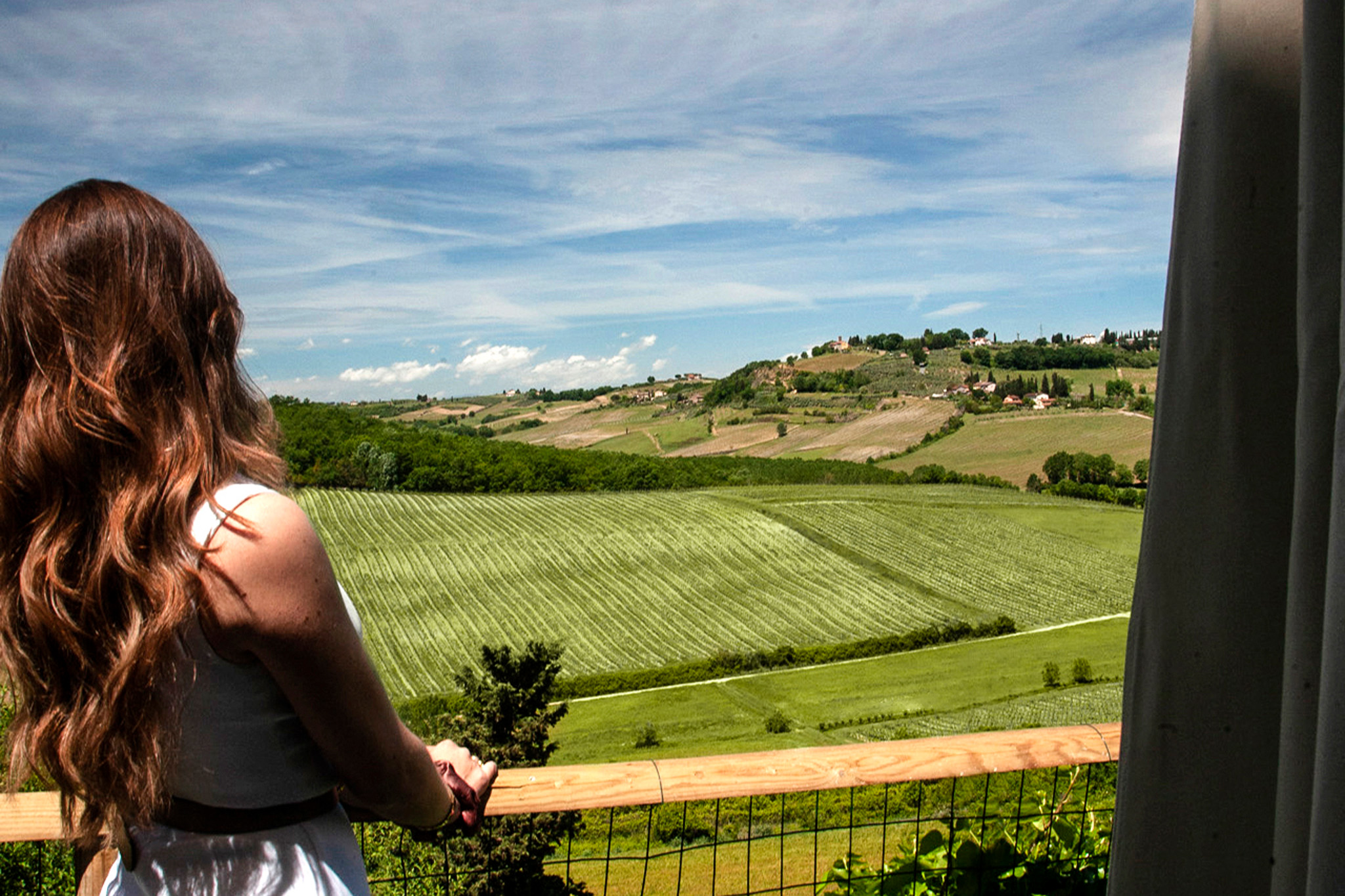 Ospite affacciata da una terrazza sui vigneti e sulle colline toscane vicino a San Gimignano