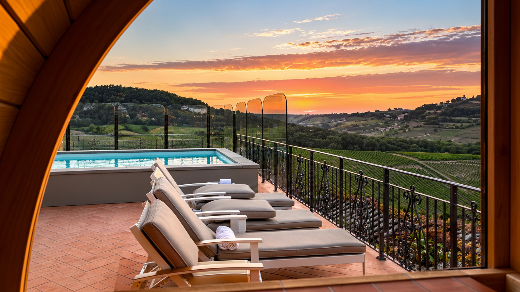 Tramonto sui vigneti visto dalla terrazza di Hotel Torciano, con piscina, lettini e colline sullo sfondo