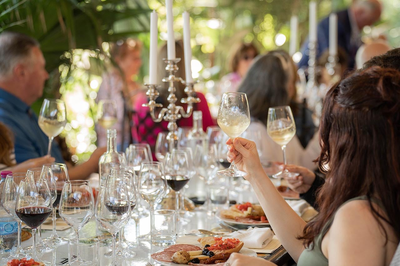 Tavolo della Wine School a Tenuta Torciano con molti calici di bianco e rosso e piatti toscani